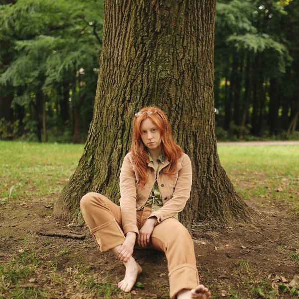 A person stretching outdoors, looking serene and comfortable.